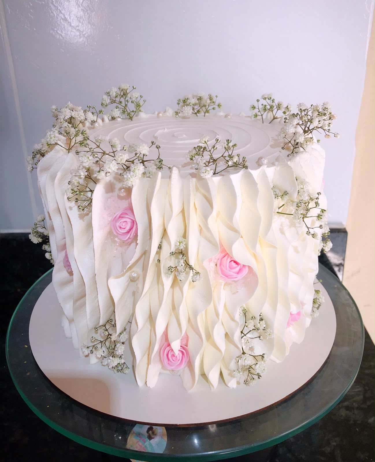 Bolo branco de babados com mini rosas e flores de gipsofila